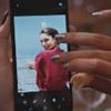 Uma foto de Sabrina Petraglia, sorridente e na frente do mar, está na tela do celular de Jéssica (Rafa Kalimann) em Família É Tudo